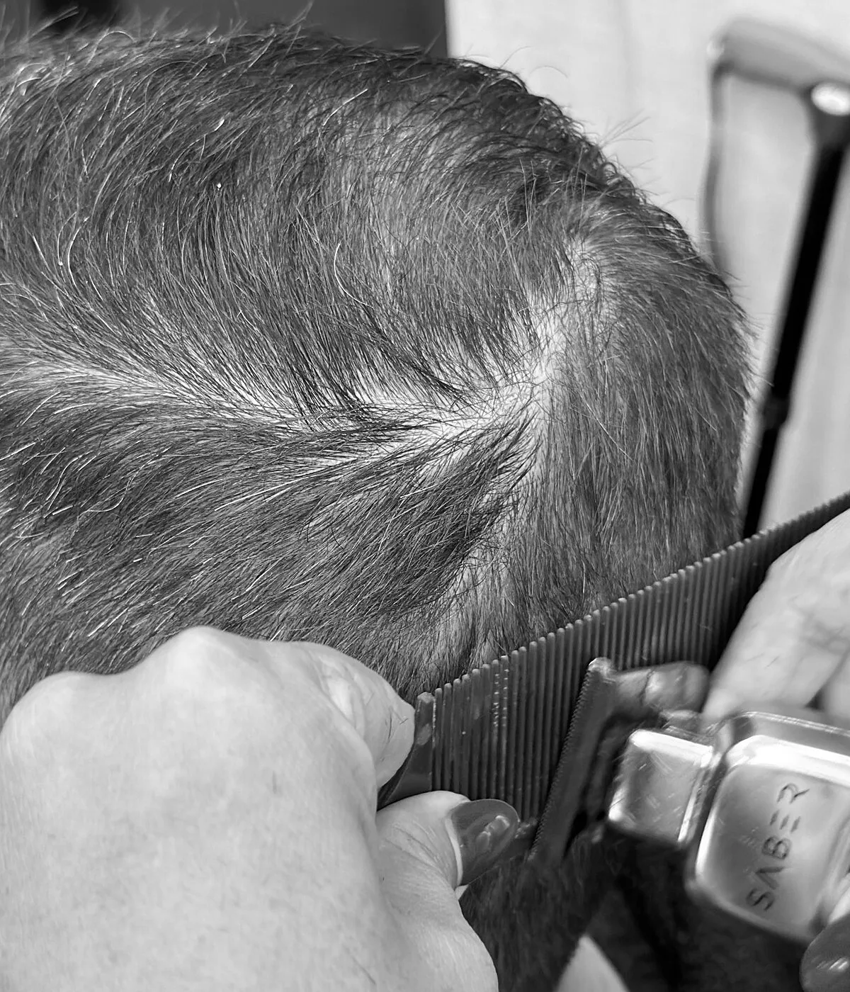 Barber clipper-cutting a client's hair at Arturo's Barbershop in Santa Barbara