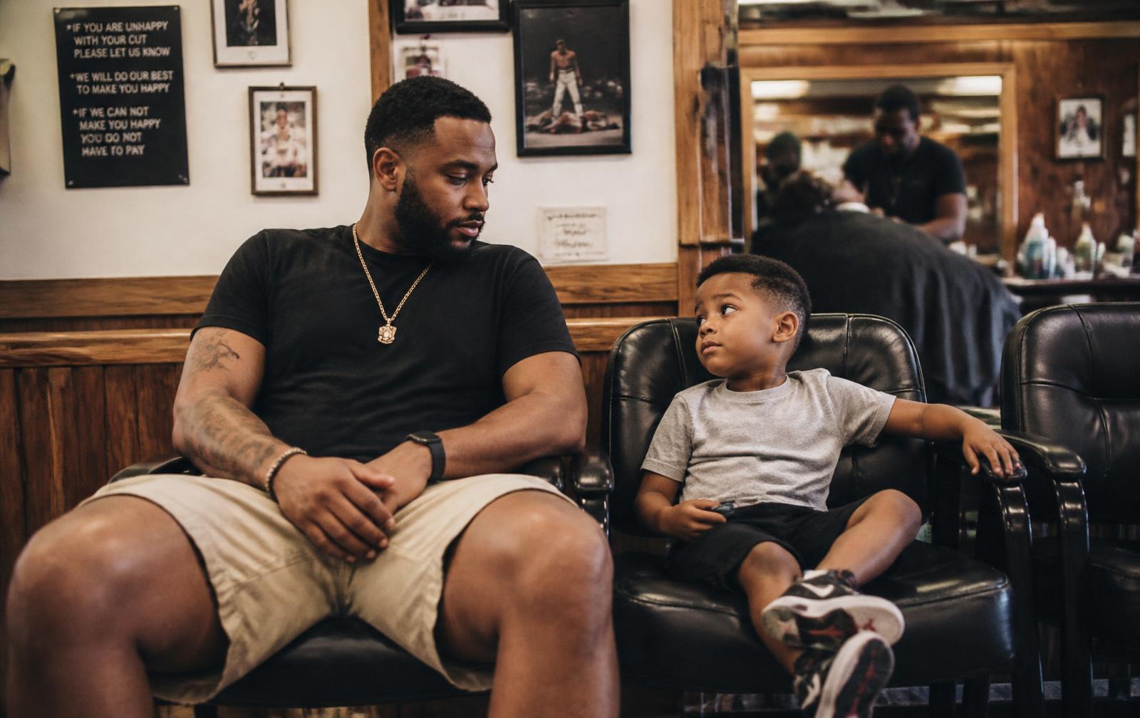 A father and son waiting together in the barbershop
